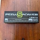 Černý napájecí adaptér pro efektové pedály s nápisem PEDAL POWER a LEWITZ. Na spodní části je tabulka s označením DC 18V IN, DC 9V OUTPUTS (výstupy 1…