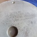 Detail kovového povrchu s nápisy a kulatým otvorem s mřížkou. Je zde čitelný text ELECTRO-VOICE INC., MODEL 12L OEM TYPE a (LIMITED) WARRANTY. Povrch…