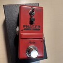 Červený kytarový efekt pedál s nápisem PHASER. Na horní části jsou umístěny přepínací spínač s označením VINTAGE a MODERN, otočný knoflík SPEED a šip…