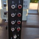 Záběr na zadní panel černého elektronického zařízení. Jsou zde vidět vstupy a výstupy s popisky: micro (left, right), phono (left, right), CD1, CD2,…