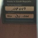 Detailní záběr na štítek s informacemi o výrobku. Na černém pozadí je nápis Made in Czech Republic a pod ním Serial Number: s ručně zapsaným číslem 1…