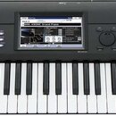 Černý digitální klavír s bílými a černými klávesami. Na pravé straně panelu je bílý nápis KORG a pod ním model KROME MUSIC WORKSTATION. Uprostřed se…