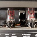 Detailní pohled na dvě elektronky v zesilovači. Levá elektronka má červené logo s písmenem J a nápis EL 84, pravá elektronka má stejné logo a nápis 6…