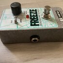 Kytarový efekt pedál v šedém kovovém šasi s bílo-zeleným horním panelem. Na panelu je nápis FREEZE SOUND RETAINER, logo nano a text MADE IN NYC, USA.…