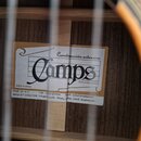 Detail vnitřku akustické kytary s viditelnou štítkem výrobce. Na štítku je nápis „Construcción artesana“, logo „Camps“ a text „PORQUERES (Girona)“ a…