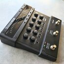 Černý procesor vokalových efektů s nápisem VOCALIST LIVE 3. Zařízení obsahuje několik ovládacích knoflíků s popisky jako WARMTH, PITCH CORRECT, GUITA…
