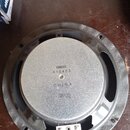 Fotografie znázorňuje zadní stranu reproduktoru s černým plastovým rámem a stříbrným kovovým magnetem. Na magnetu je vyražen nápis YAMAHA, níže číslo…