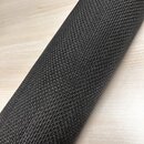 Fotografie ukazuje detail černého textilu s výraznou pletenou strukturou. Materiál je srolován do válce a položen na světlém dřevěném povrchu. Na sní…