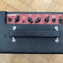 Černý basový kombozesilovač s červeným ovládacím panelem. Na panelu je nápis Pathfinder Bass 10 a ovládací prvky s popisky INPUT, DRIVE, BRIGHT (OFF/…