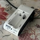 Bílý plastový přístroj s otevřeným přihradou na baterie. Na bílém štítku je uveden nápis TASCAM, pod ním nečitelný znak a XZ a dále TEAC CORPORATION.…