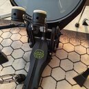 Černý dvojpedál na basový buben s bílými plstěnými beatery. Na stupni je umístěno zeleno-žluté logo s nápisem MAPEX. Pedál je vyroben z kovu a plastu…