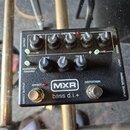 Černý kytarový pedál s nápisy MXR a bass d.i.+ . Zařízení obsahuje pět otočných potenciometrů s popisky BASS, MID, TREBLE, GAIN a GATE, dva zapínací…