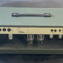 Zadní strana kytarového komba v zeleném potahu s černou rukojetí. Na zadním panelu je nápis MODEL VALVE / POWER 230V / 50 Hz AC / TN - S SPEAKER OUTP…