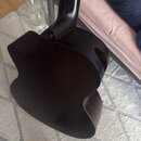 Fotografie zachycuje zadní část trupu a krku akustické kytary v tmavě hnědé až černé barvě. Povrch je matný a bez viditelných značek, log nebo nápisů…