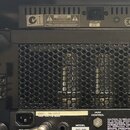 Zadní strana černého zesilovače s kovovou perforovanou mřížkou, skrz kterou jsou vidět elektronické válvy. Na spodním černém panelu jsou nápisy MODEL…