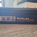 Černý svátkový panel světelného pultu. Na boku je bílý nápis SGM Studio 24 SCAN CONTROL professional light desk s doprovodným logem z teček. Povrch v…