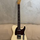 Krémově bílá elektrická kytara typu Telecaster s tmavě hnědým puntovaným pickguardem. Na hlavě hmatníku je viditelné logo Fender. Nástroj má javorový…