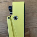 Žlutý efekt pedál z kovu s černými ovratovými knoflíky. Na boku je vidět jeden kovový vstupní/výstupní konektor a jeden šroub. Povrch je mírně znečiš…