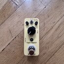 Krémový efekt pedál s nápisy FUNKY MONKEY a MOOG. Na horní straně jsou ovládací prvky: dva malé černé knoflíky u nápisů RANGE a Q, jeden velký černý…