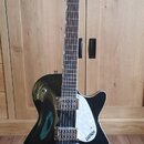 Černá elektrická kytara s tmavým hmatníkem a bílým trsátorem. Na hlavě i na trsátoru je bílý nápis GRETSCH. Nástroj má dva snímače typu humbucker a j…