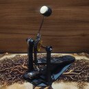 Černý basový pedál s kovovou základnou a stříbrným šlapadlem. Na černém plastovém těle pedálu je viditelné logo a nápis "Trickfoot". Mechanismus obsa…