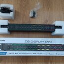 Fotografie zobrazuje černý rackový přístroj s LED indikátory úrovně, umístěný v polystyrenovém obalu. Na přístroji je nápis AMERICAN AUDIO a DB DISPL…