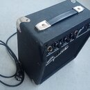 Černý kytarový kombozesilovač s texturovaným povrchem a černou rukojetí. Na předním panelu jsou nápisy INPUT, VOLUME, TREBLE, BASS a TONE, dále označ…