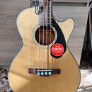 Akustická basová kytara s přímým výřezem v korpusu, přírodní barvou dřeva a černým lemováním. Na ozvukové desce je v rozetě nápis Fender CLASSIC DESI…