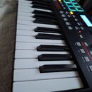 Černý MIDI kontrolér s klávesnicí. Na horním panelu je nápis AKAI a modelové označení MPK225. Zařízení obsahuje osm zeleně podsvícených padů, displej…