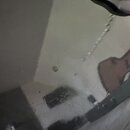 Detailní záběr na černý, lesklý povrch hudebního nástroje. Na povrchu jsou vidět odrazy okolí a několik drobných světlých skvrn či nečistot. V pravém…