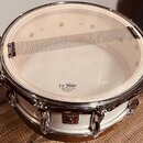 Bílá bubenová kože v chromovaném obruči s připevněným tlumicím páskem. Na kože je čitelný nápis UT REMO CLEAR HEAD MADE BY REMO IN CHINA. Na korpusu…