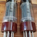 Dvě elektronky v prohladněných skleněných baňkách s hnědými plastovými základnami a kovovými piny. Na každé je vidět nápis Marshall, označení EL34 a…