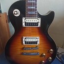 Elektrická kytara s trupem v barevnosti sunburst a černým pickguardem. Na přepínači je viditelný nápis RHYTHM TREBLE a na spodním snímači je nápis R.…