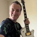 Bílá elektrická kytara s tvarem singlecut a zlatým hardwarem. Na hlavě hmatníku je vidět nápis „LTD“. Kytara má dva humbuckery s krytkami a zlaté lad…