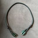 Tmavě zelený audio kabel v textilním opletení. Kabel je zakončen dvěma dvojicemi konektorů typu jack v zeleném provedení. Na kabelu nejsou žádné vidi…