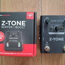 Černý efekt pedál s kovovým povrchem a dvěma stoupacími spínači označenými BOOST a BYPASS. Na zařízení je bílý nápis Z-TONE a ovládací panel s knoflí…