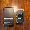 Fotografie zobrazuje černý kartonový obal a stříbrný efekt pedál značky BOSS. Na obalu je nápis SL-2 EXP 425011A 99 Z1P6782, USE BOSS PSA ADAPTOR ONL…