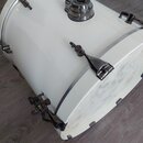 Bílý basový buben s chromovaným kováním. Na koruse je viditelné logo ve tvaru oválu s nápisem "ASCERIE". Povrch nástroje vykazuje v dolní části vidit…