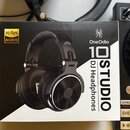 Fotografie znázorňuje krabici s černými DJ headphones. Na obalu je uveden název značky OneOdio a model 10 STUDIO. V levém horním rohu je žlutý štítek…