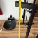 Černý kovový stojan s hranatým profilem. K měření výšky je k němu přiložen žlutývrtací metr, který ukazuje hodnotu mírně nad 80 cm. V pozadí je vidět…