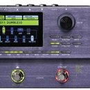 Multiefektový procesor pro kytaru v kovovém šedém provedení. Na zařízení je nápis GE 200 Amp modelling & Multi Effects a logo MOOER. Displej zobrazuj…