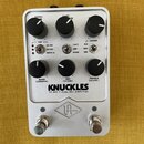 Stříbrný kytarový pedál s nápisem KNUCKLES a pod ním textem '92 REV F DUAL REC AMPLIFIER. Na horní části jsou tři černé otočné ovladače s popisky [RO…