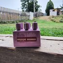 Fialový efekt pedál s čtyřmi kovovými knoflíky. Na horní straně jsou bílé nápisy: TIME #, MODEPTH U, MODIFY #, LENGTH U, BOUNCE U, POLARITY U, CLASSI…