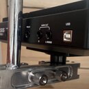 Detail zadní strany černého elektronického zařízení s nápisy ALESIS a SAMPLER-1. Jsou vidět konektory s popisky TRIG IN, MAIN OUT (R a L/MONO) a USB.…