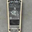 Zadní strana efekt pedálu s krémovým rámem a černým kovovým krytem. Na krytu je bílý nápis cry baby, podpis Jimi Hendrix a text JH-1B JIMI HENDRIX SI…