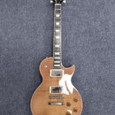 Elektrická kytara s hnědým průsvitným lakem a viditnou strukturou dřeva. Na hlavě je bílý nápis "TKN". Nástroj má dva humbuckery, bílý plechtrpicku n…