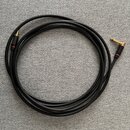 Černý audio kabel s úhlovým konektorem na jednom konci. Konektor je vyroben z kovového materiálu zlaté barvy s červeným prstencem u základny. Kabel j…