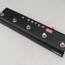 Černý obdélníkový nožní spínač s kovovým rámem a pěti stříbrnými tlačítky. Na horní části je bílý nápis AIRSTEP a červené tlačítko s bílým nápisem Sp…
