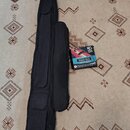 Černý textilní obal na hudební nástroj s bílým nápisem NS DESIGN v horní části. Vedle obalu leží krabička s nápisy NS DESIGN strings a double bass. P…