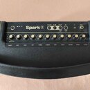 Černý kytarový kombozesilovač s nápisem Spark 2. Na horním panelu jsou umístěny ovládací knoflíky s popisky PRESET, GAIN, BASS, MID, TREBLE, MASTER,…